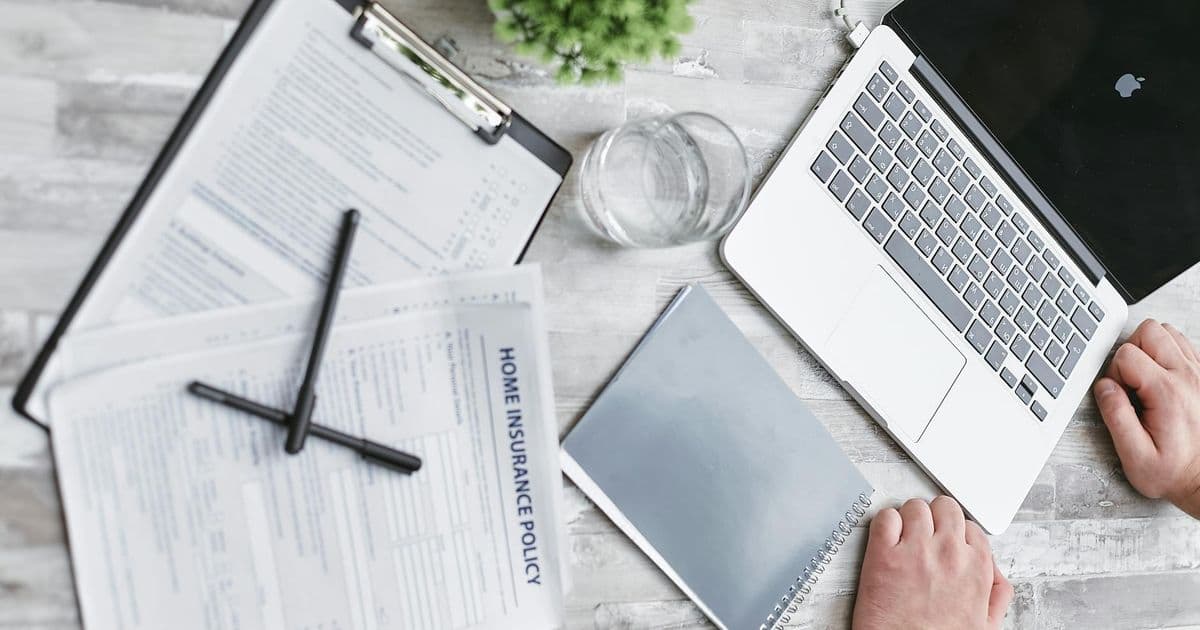 Insurance documents spread on a desk being reviewed carefully